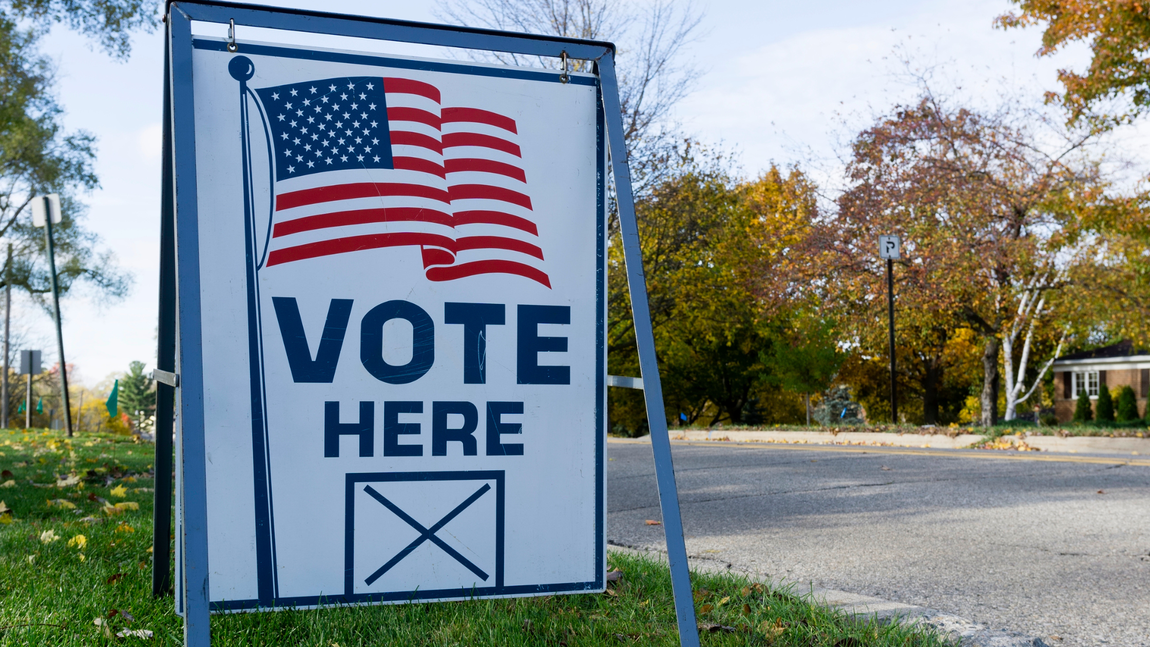 vote here sign with an American flag on it